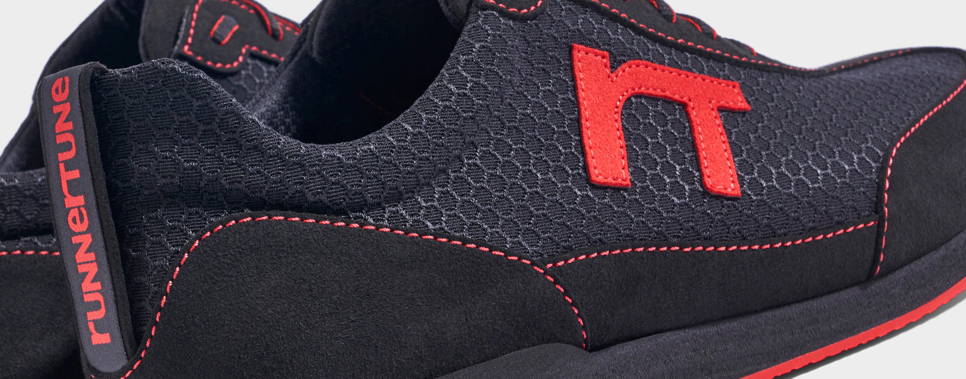 Laufschuh Runnertune Pace Original – schwarzes Waben-Textil und schwarzes Velour, schwarze Sohle – Paaransicht schräg von hinten