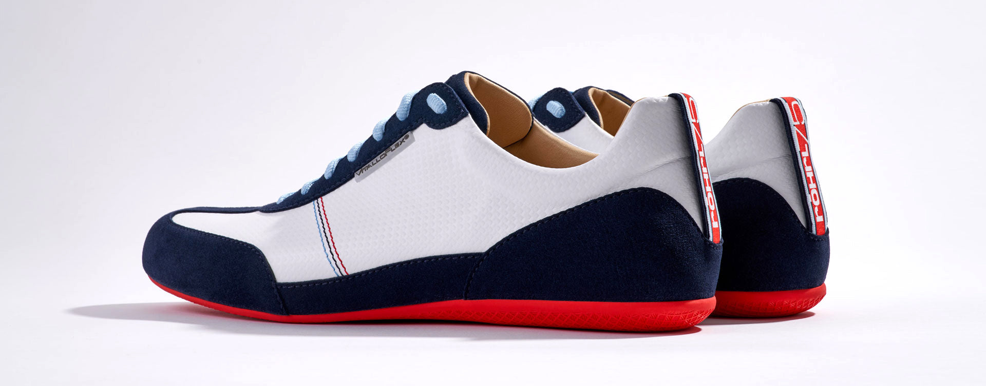 Sneaker VitalloFlex Puro RS RÖHRL75 – weißes Carbon und dunkelblaues Velour, rote Sohle – Paaransicht schräg von hinten