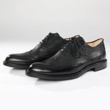 Maßgefertigter klassischer Herrenschuh Vitallo Brogue – schwarzes Boxcalf und Chevreau, schwarze Ledersohle – Paaransicht schräg von vorn