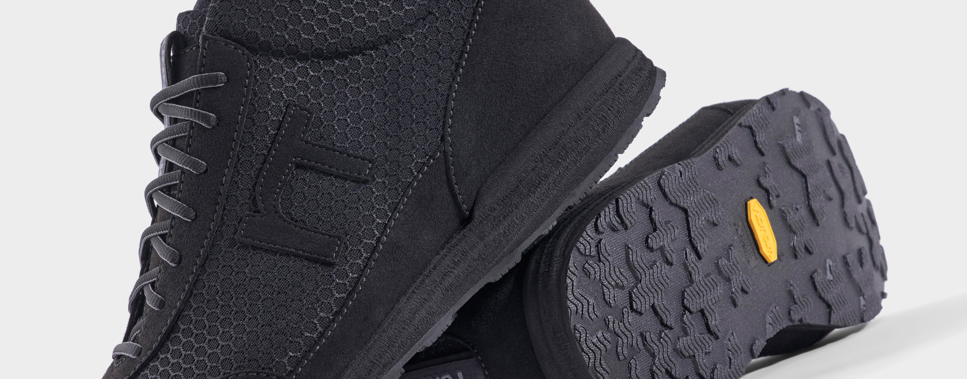 High-Top Laufschuh Runnertune X-Pace Black – schwarzes Waben-Textil und schwarzes Velour, schwarze Sohle – Paaransicht mit Laufsohle