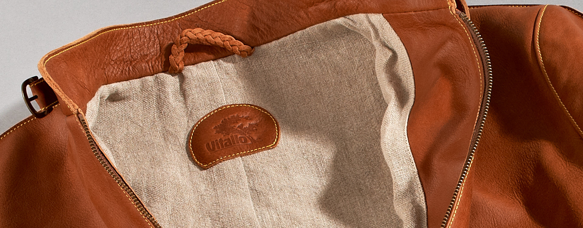 Maßgefertigte Vitallo Lederjacke – braunes Pull-Up-Leder mit gelben Akzenten – Detailansicht von Logo und Innenfutter