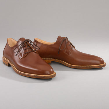 Maßgefertigter klassischer Herrenschuh Vitallo Blücher – mittelbraunes Chevreau-Leder, braune Ledersohle – Paaransicht schräg von vorn