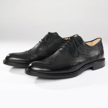 Maßgefertigter klassischer Herrenschuh Vitallo Brogue – schwarzes Boxcalf und Chevreau, schwarze Ledersohle – Paaransicht schräg von vorn